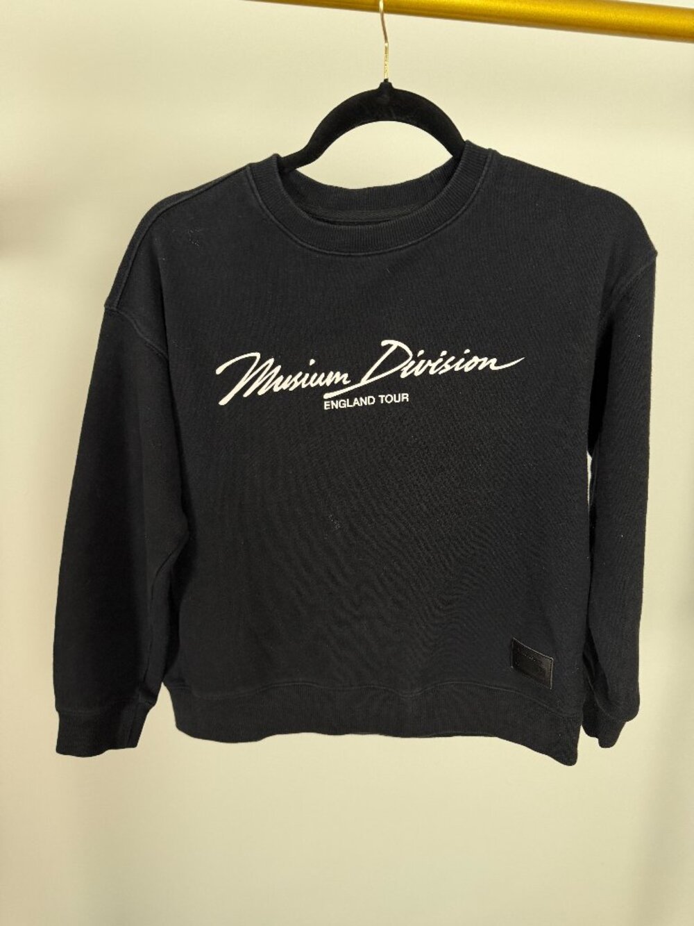 I.T Musium Division. Black crew neck sweater with graphic patch on back.